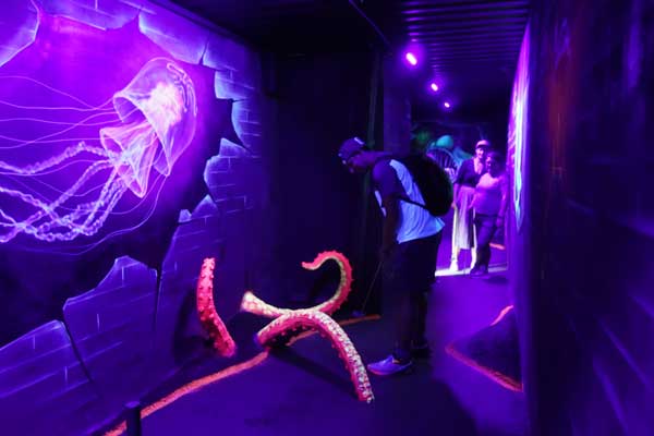 A person golfing in a dark room.